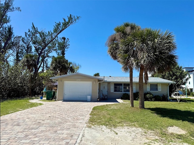 ranch-style home with decorative driveway, an attached garage, and a front lawn