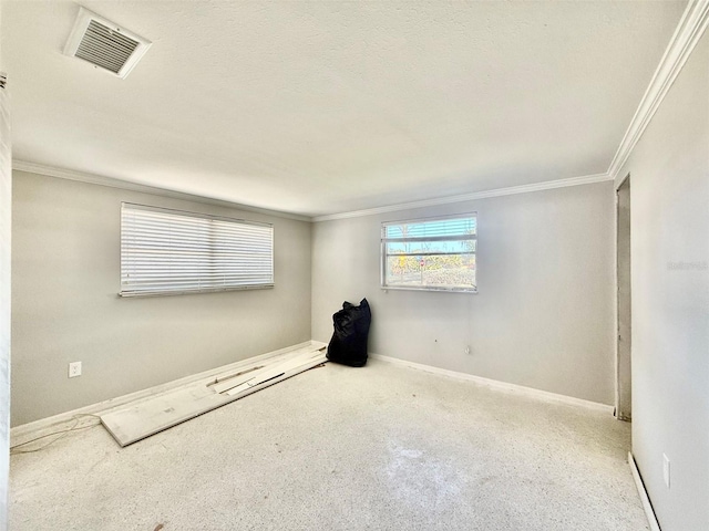 empty room featuring ornamental molding, visible vents, and baseboards