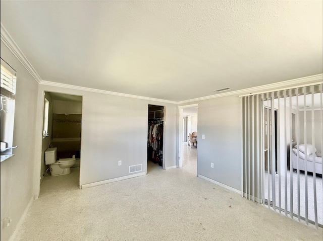 bedroom featuring baseboards, a closet, visible vents, and crown molding