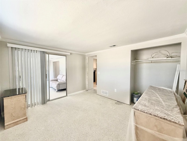 bedroom with a closet, visible vents, a textured ceiling, and ornamental molding