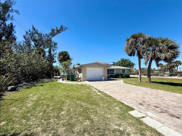 view of front of home featuring a front yard, decorative driveway, and an attached garage