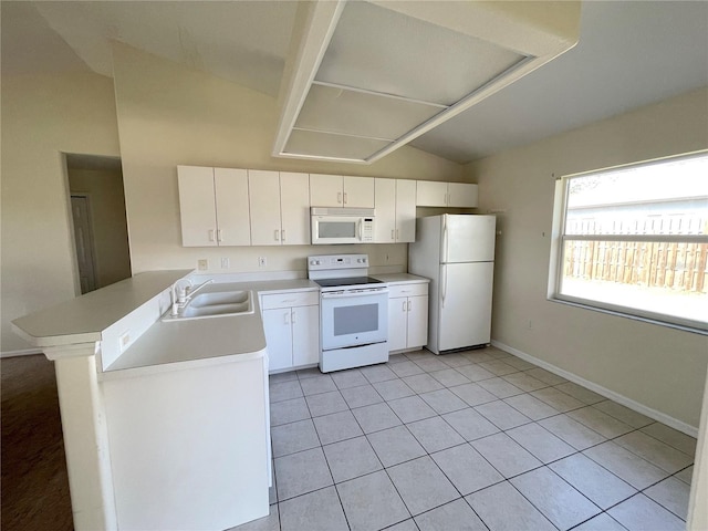 kitchen featuring light countertops, lofted ceiling, a peninsula, white appliances, and a sink