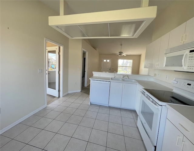 kitchen with light tile patterned floors, a peninsula, white appliances, white cabinetry, and a sink