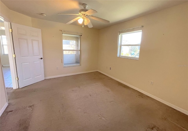 unfurnished room with a ceiling fan, baseboards, and carpet floors