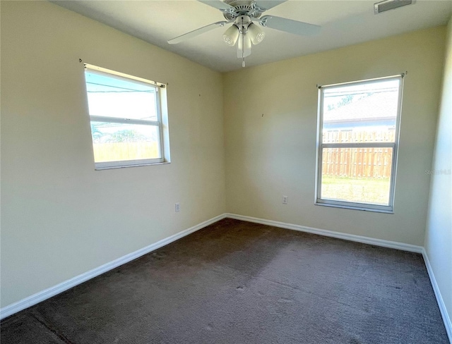 spare room with visible vents, baseboards, ceiling fan, and carpet flooring