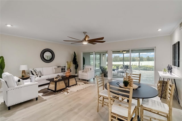 dining area featuring a wealth of natural light, light wood-style floors, ornamental molding, and a ceiling fan