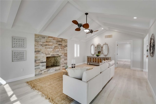 living area featuring light wood finished floors, visible vents, vaulted ceiling with beams, and a ceiling fan