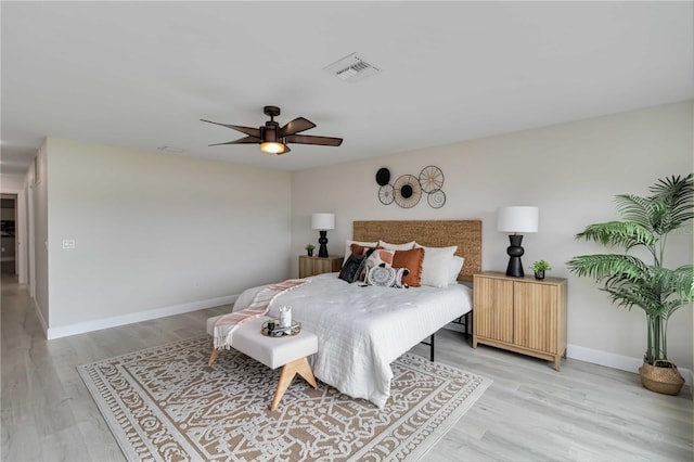 bedroom featuring visible vents, a ceiling fan, light wood-style floors, and baseboards