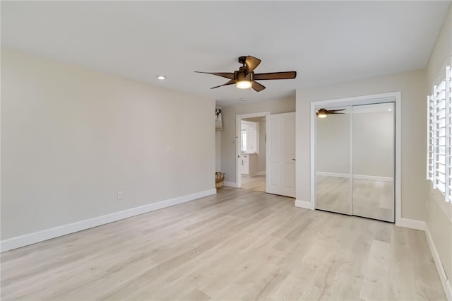 unfurnished bedroom with a closet, ceiling fan, baseboards, and light wood-style floors