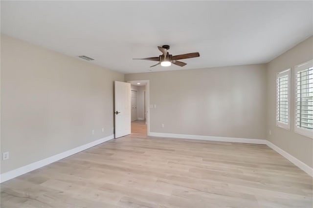 unfurnished room featuring light wood finished floors, visible vents, ceiling fan, and baseboards