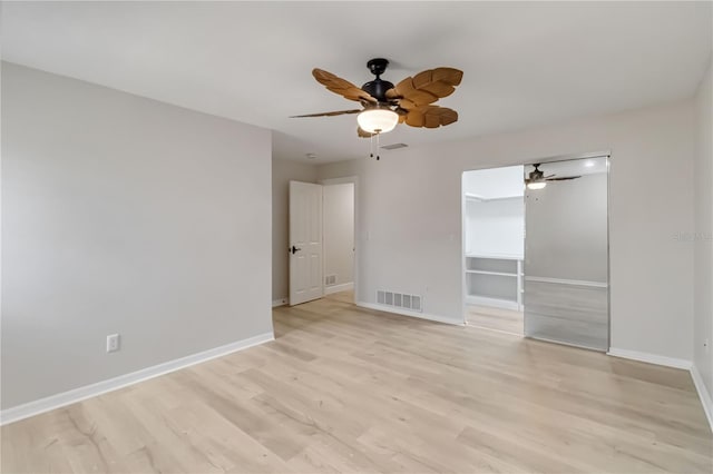 unfurnished bedroom featuring a ceiling fan, light wood-style floors, visible vents, and baseboards