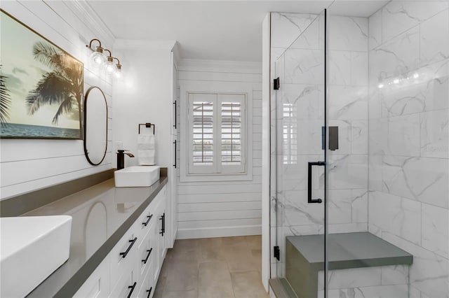 bathroom with baseboards, a marble finish shower, double vanity, ornamental molding, and a sink