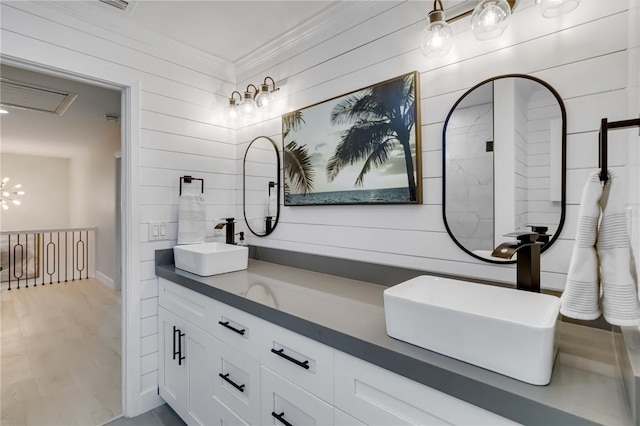 full bathroom with double vanity, a chandelier, ornamental molding, and a sink