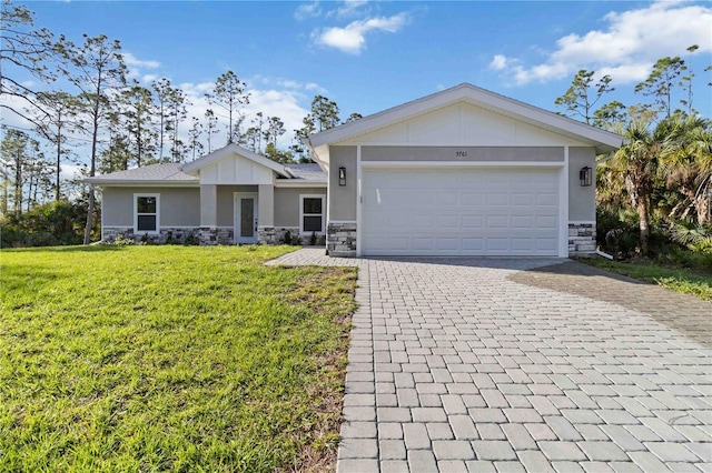 view of front of house featuring a front lawn, stucco siding, decorative driveway, a garage, and stone siding