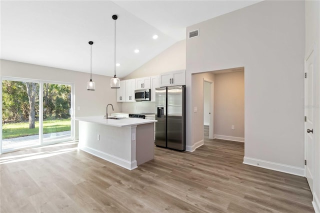 kitchen with appliances with stainless steel finishes, light countertops, light wood-type flooring, and a sink