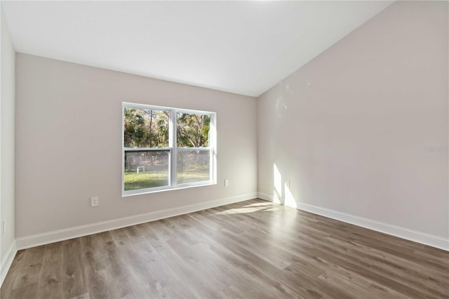 spare room featuring baseboards and wood finished floors