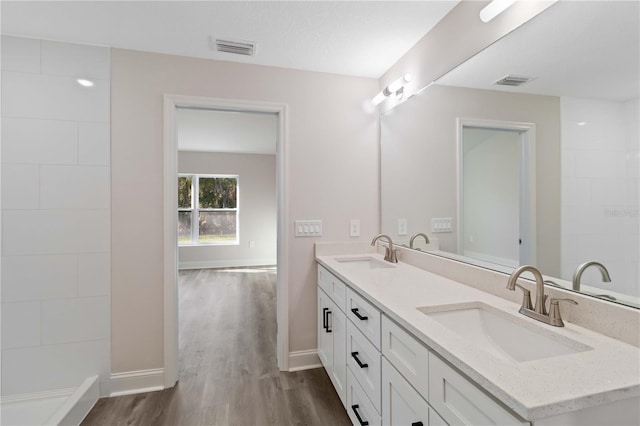 full bathroom featuring wood finished floors, visible vents, and a sink