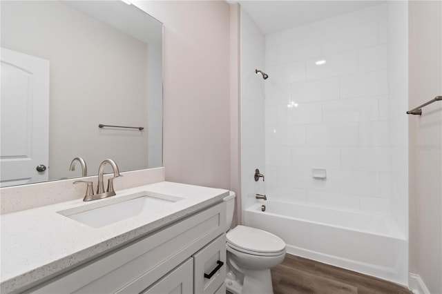 full bath featuring shower / bath combination, toilet, wood finished floors, and vanity