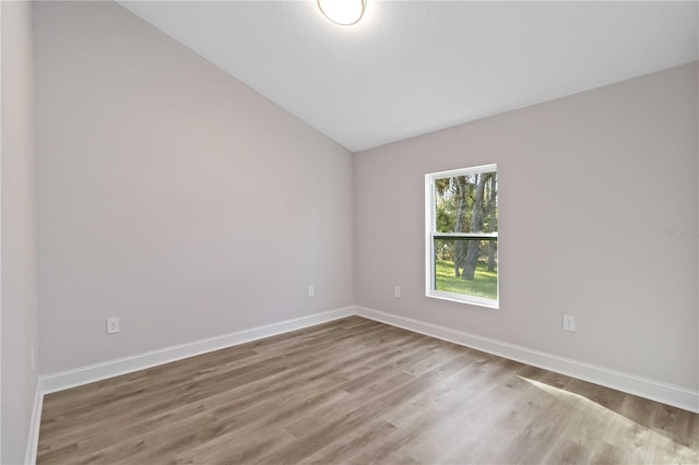 spare room featuring baseboards and wood finished floors