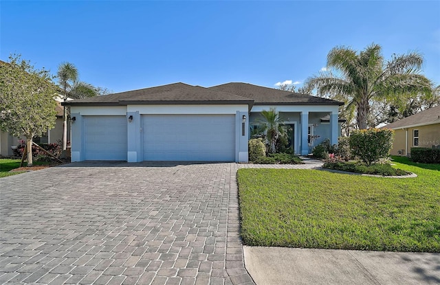 single story home featuring a front yard, decorative driveway, a garage, and stucco siding