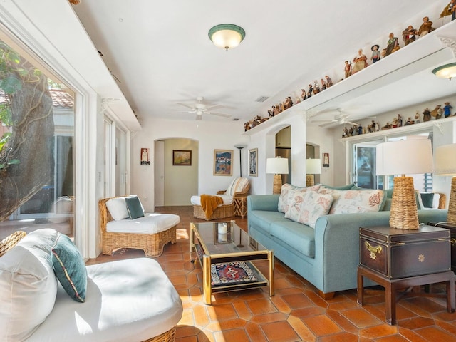 sunroom featuring a ceiling fan and arched walkways