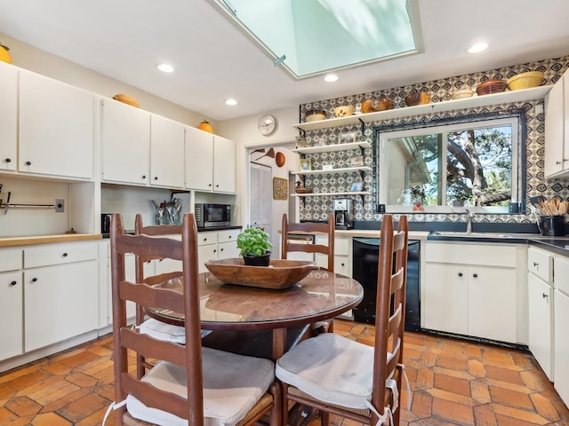 kitchen with stainless steel microwave, recessed lighting, white cabinetry, and black dishwasher