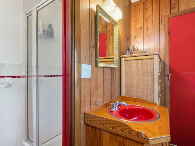 bathroom featuring a stall shower, vanity, and wood walls