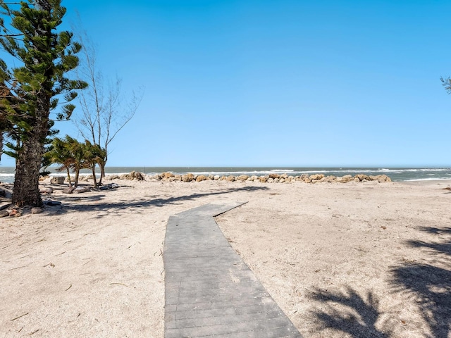 view of yard featuring a water view and a beach view