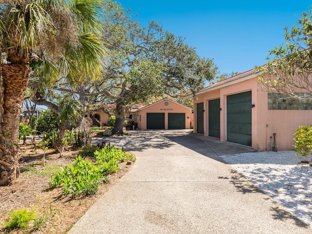 exterior space featuring stucco siding, a garage, and driveway