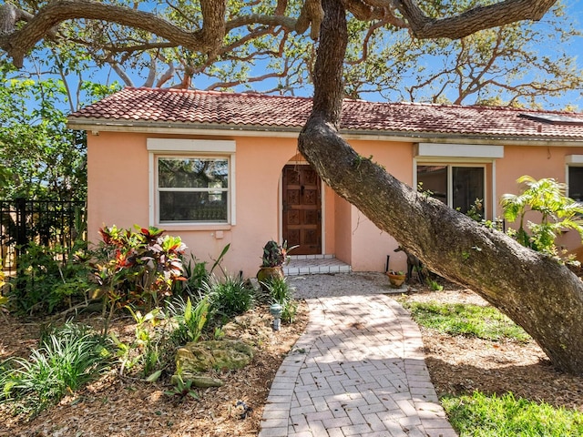 view of front of property featuring stucco siding and fence