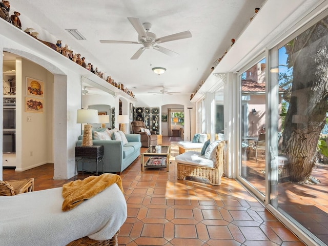 sunroom featuring visible vents, arched walkways, and ceiling fan