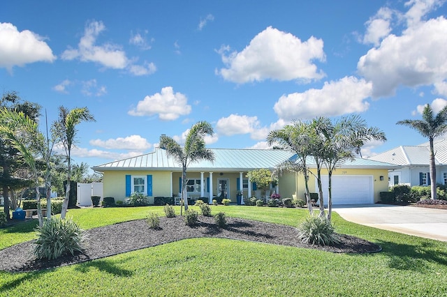 ranch-style house featuring a standing seam roof, driveway, a front lawn, and a garage