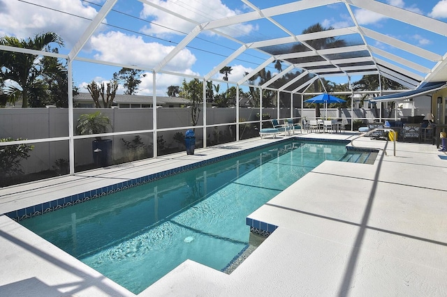 view of swimming pool featuring glass enclosure, a fenced in pool, a patio area, and fence