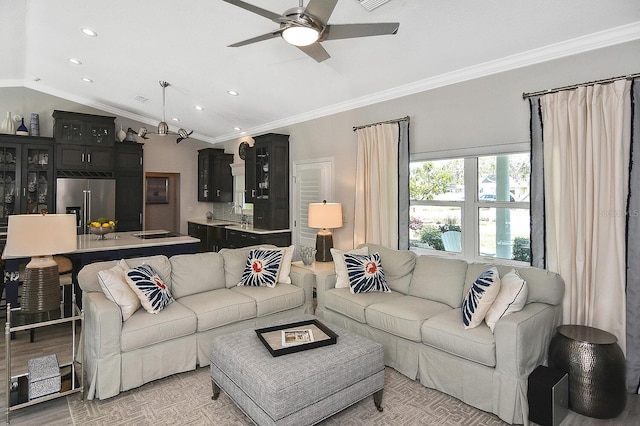 living room with lofted ceiling, recessed lighting, ceiling fan, crown molding, and light wood-type flooring