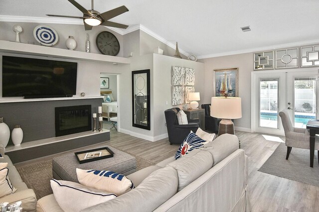 living room featuring visible vents, ornamental molding, wood finished floors, french doors, and lofted ceiling