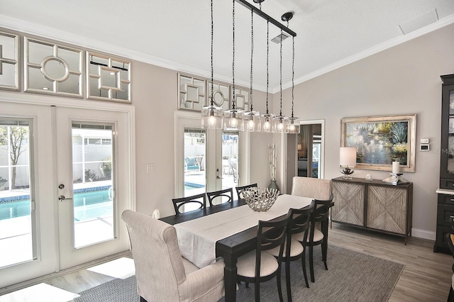 dining space with french doors, wood finished floors, and ornamental molding