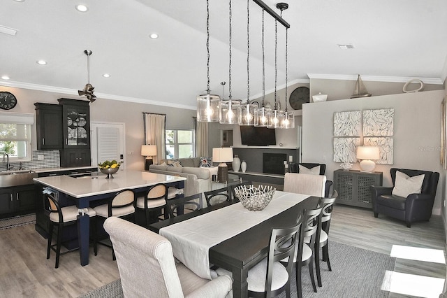 dining area featuring plenty of natural light, crown molding, and lofted ceiling