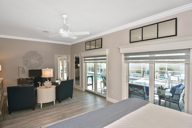 bedroom featuring visible vents, access to outside, wood finished floors, crown molding, and baseboards