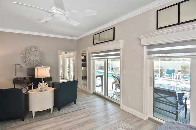 interior space featuring baseboards, light wood-style floors, ceiling fan, and crown molding