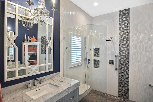 full bath with a walk in shower, vanity, and an inviting chandelier