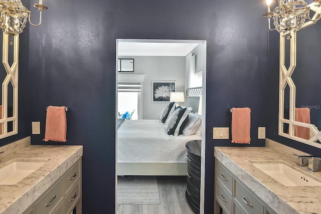 full bathroom featuring a sink, connected bathroom, an inviting chandelier, and wood finished floors