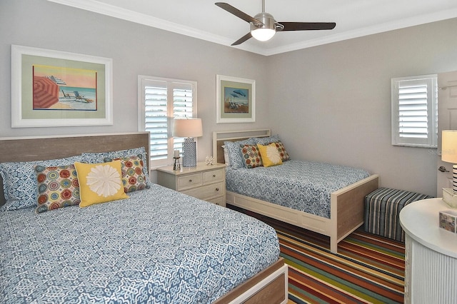 bedroom featuring multiple windows, crown molding, and a ceiling fan