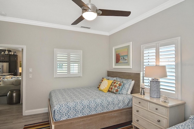 bedroom with wood finished floors, visible vents, baseboards, ceiling fan, and crown molding