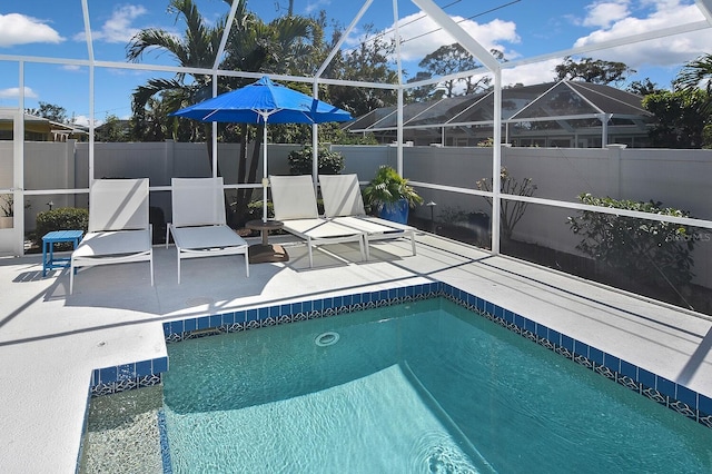 view of swimming pool with a fenced in pool, fence, a lanai, and a patio area