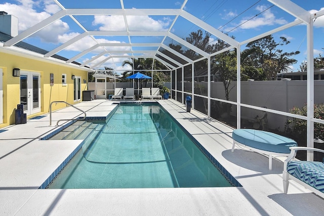 view of swimming pool with a patio, a fenced backyard, french doors, glass enclosure, and a fenced in pool