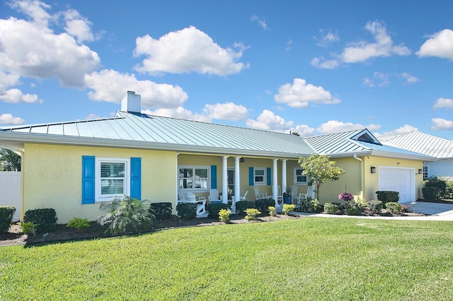 single story home featuring stucco siding, a standing seam roof, metal roof, a front yard, and a garage