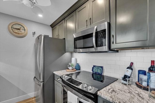 kitchen with decorative backsplash, light stone counters, ceiling fan, and stainless steel appliances