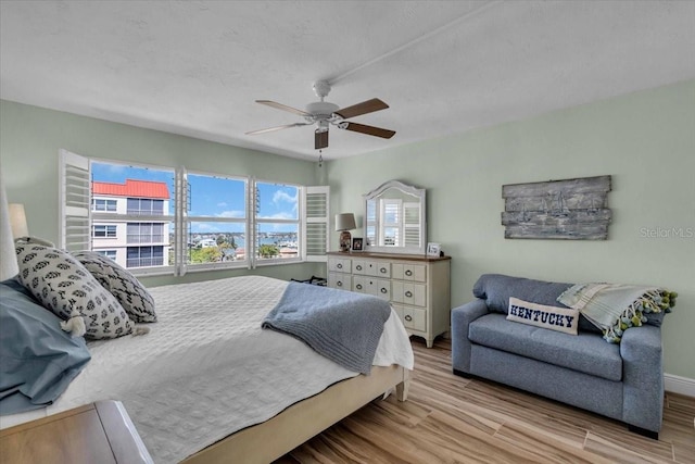 bedroom featuring baseboards, ceiling fan, and wood finished floors