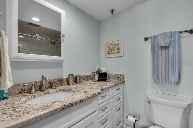 full bathroom with visible vents, toilet, vanity, and walk in shower