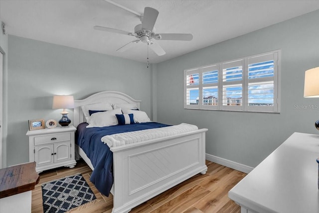 bedroom featuring baseboards, light wood-style floors, and ceiling fan